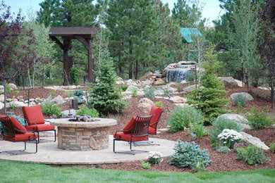Inspiration for a mid-sized traditional backyard stone landscaping in Toronto with a fire pit.