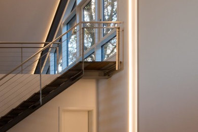 This is an example of a large modern hallway in Hamburg with white walls, medium hardwood floors and brown floor.
