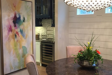 Mid-sized trendy light wood floor enclosed dining room photo with white walls