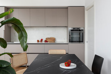 Idee per una cucina minimalista di medie dimensioni con lavello da incasso, ante lisce, top in marmo, paraspruzzi in marmo, elettrodomestici in acciaio inossidabile e parquet chiaro