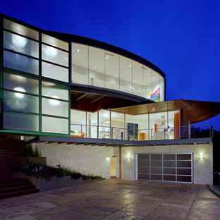 Exempel på ett stort modernt vitt hus, med tre eller fler plan, glasfasad, platt tak och tak i metall