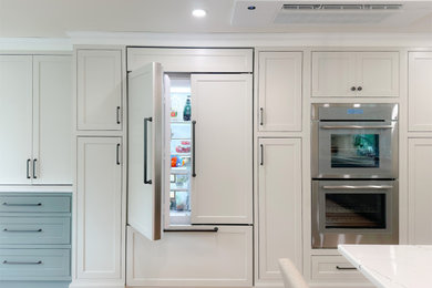 Inspiration for a l-shaped light wood floor and brown floor dry bar remodel in Boston with an undermount sink, recessed-panel cabinets, green cabinets, quartz countertops, multicolored backsplash, mosaic tile backsplash and white countertops