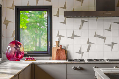 Inspiration for a large contemporary u-shaped medium tone wood floor, brown floor and vaulted ceiling eat-in kitchen remodel in Seattle with an undermount sink, flat-panel cabinets, beige cabinets, quartzite countertops, white backsplash, marble backsplash, paneled appliances, an island and beige countertops