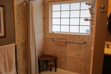 Example of a mid-sized classic stone tile ceramic tile bathroom design in Cleveland with an undermount sink, raised-panel cabinets, medium tone wood cabinets, solid surface countertops, a two-piece toilet and beige walls