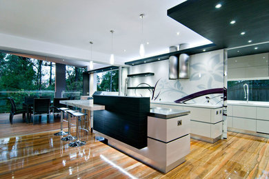 Open concept kitchen - mid-sized modern single-wall medium tone wood floor and brown floor open concept kitchen idea in Toronto with flat-panel cabinets, white cabinets, quartzite countertops, an island, an undermount sink and multicolored backsplash