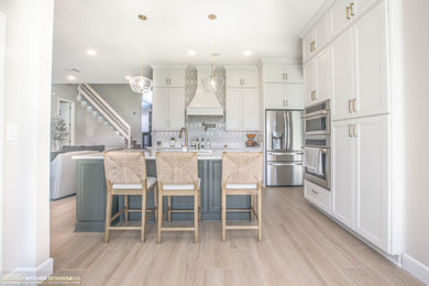 Kitchen pantry - mid-sized transitional l-shaped porcelain tile and beige floor kitchen pantry idea in Orlando with an undermount sink, recessed-panel cabinets, beige cabinets, quartz countertops, beige backsplash, an island and beige countertops