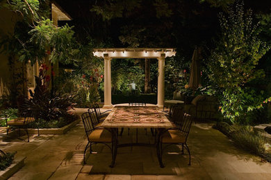 This is an example of a large tropical backyard patio in San Francisco with tile and a pergola.