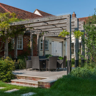 Medium sized rustic back formal garden in Hertfordshire with a garden path and natural stone paving.