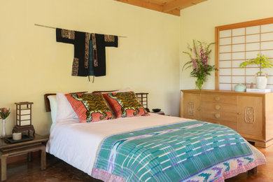 Bedroom - eclectic concrete floor and exposed beam bedroom idea in Other with yellow walls