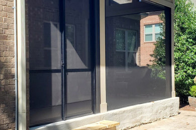 Mid-sized concrete paver screened-in back porch photo in Charlotte with a roof extension