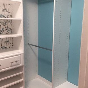 Esempio di una piccola cabina armadio per donna classica con ante con bugna sagomata, ante bianche, pavimento in legno massello medio e pavimento rosso