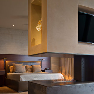 Geräumiges Modernes Hauptschlafzimmer mit beiger Wandfarbe, braunem Holzboden, Tunnelkamin und Kaminumrandung aus Metall in San Francisco