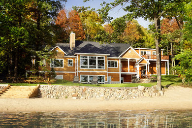Example of an arts and crafts brown two-story wood gable roof design in Other