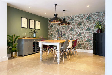 Imagen de comedor ecléctico grande abierto sin chimenea con paredes verdes, suelo de madera en tonos medios, suelo marrón y papel pintado