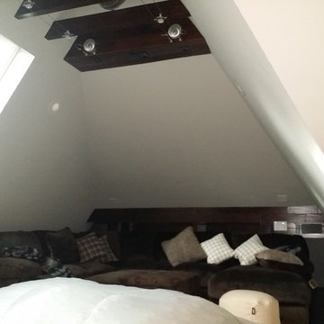 MEDIA ROOM IN AN ATTIC SPACE- EXPOSED INDUSTRIAL A/C- WOOD FLOOR , CEILING BEAMS