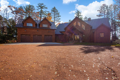 Example of a mountain style brown concrete house exterior design in Other with a metal roof