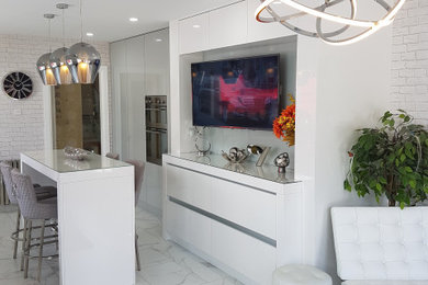 This is an example of a modern galley kitchen/diner with a built-in sink, flat-panel cabinets, white cabinets, composite countertops, stainless steel appliances, porcelain flooring, an island, white floors and grey worktops.