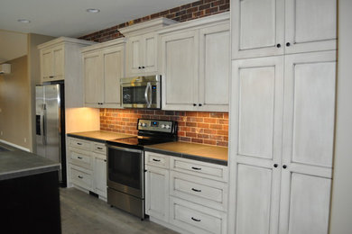 Elegant eat-in kitchen photo in Other with an undermount sink, shaker cabinets, white cabinets, tile countertops, multicolored backsplash and stainless steel appliances