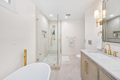 Mid-sized minimalist master white tile and ceramic tile ceramic tile, beige floor and double-sink bathroom photo in Dallas with flat-panel cabinets, light wood cabinets, a two-piece toilet, white walls, an undermount sink, quartz countertops, a hinged shower door, multicolored countertops, a niche and a built-in vanity