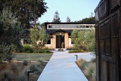 Стильный дизайн: большой солнечный, летний засухоустойчивый сад в стиле модернизм с хорошей освещенностью и с каменным забором - последний тренд