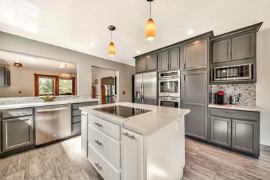 Mid-sized trendy u-shaped porcelain tile and gray floor kitchen photo in Other with an undermount sink, shaker cabinets, gray cabinets, quartz countertops, gray backsplash, marble backsplash, stainless steel appliances, an island and white countertops