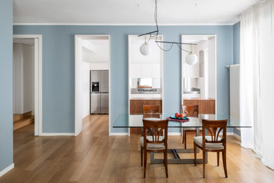 Imagen de comedor minimalista extra grande abierto con paredes azules y suelo de madera clara