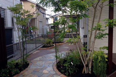 Diseño de jardín minimalista de tamaño medio en verano en patio lateral con parterre de flores, exposición parcial al sol, adoquines de piedra natural y con madera