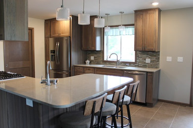 Eat-in kitchen - mid-sized transitional u-shaped ceramic tile and gray floor eat-in kitchen idea in Other with quartzite countertops, a double-bowl sink, shaker cabinets, medium tone wood cabinets, beige backsplash, matchstick tile backsplash, stainless steel appliances and a peninsula