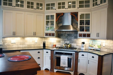 Inspiration for a farmhouse l-shaped light wood floor eat-in kitchen remodel in Orange County with a farmhouse sink, beaded inset cabinets, white cabinets, quartz countertops, gray backsplash, stone tile backsplash, stainless steel appliances and no island