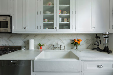 Mid-sized transitional kitchen photo in Los Angeles with a farmhouse sink, shaker cabinets, white cabinets, marble countertops, gray backsplash, subway tile backsplash and stainless steel appliances