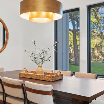 Modern Lakeside Farmhouse Dining Area with Dark Wood Table and Brass Chandelier