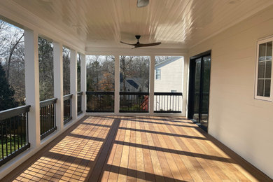Inspiration for a large transitional screened-in back porch remodel in Raleigh with a roof extension