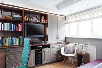Design ideas for a small contemporary guest bedroom in Kent with grey walls, laminate floors and brown floors.