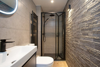 This is an example of a small contemporary bathroom in London with an alcove shower, a two-piece toilet, an integrated sink, a hinged door, a single sink and a floating vanity unit.