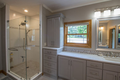 Corner shower - modern gray tile and ceramic tile ceramic tile and gray floor corner shower idea in Other with gray walls, an undermount sink, granite countertops and a hinged shower door