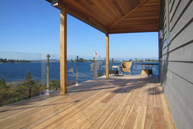 Photo of a mid-sized beach style backyard deck in Toronto with a roof extension.