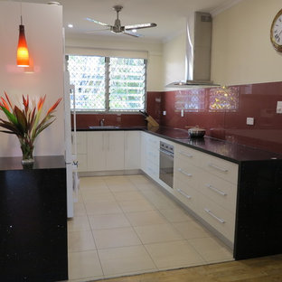 Small tropical kitchen pantry ideas - Kitchen pantry - small tropical u-shaped kitchen pantry idea in Darwin with a single-bowl sink, white cabinets, quartz countertops, red backsplash, stainless steel appliances and no island