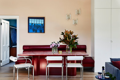 Mid-sized contemporary kitchen/dining combo in Melbourne with pink walls and light hardwood floors.