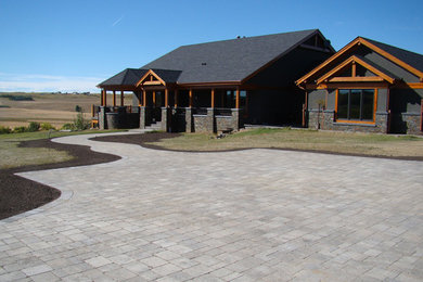 This is an example of a large traditional full sun front yard stone driveway in Calgary.