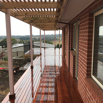Merbau deck with black balustrade and timber slatted pergola