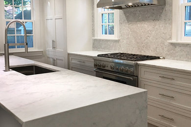 Inspiration for a transitional kitchen in New York with beaded inset cabinets, white cabinets, grey splashback, stainless steel appliances, medium hardwood floors, with island, brown floor and white benchtop.