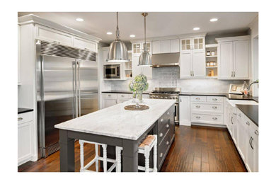 Inspiration for a mid-sized timeless u-shaped medium tone wood floor, brown floor and vaulted ceiling eat-in kitchen remodel in Chicago with a farmhouse sink, raised-panel cabinets, white cabinets, granite countertops, white backsplash, granite backsplash, stainless steel appliances, an island and black countertops