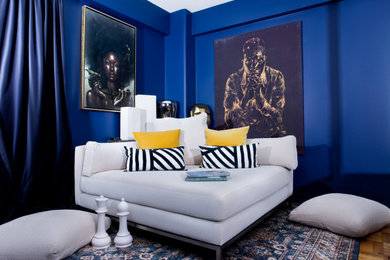 Modelo de dormitorio principal minimalista de tamaño medio con paredes azules, suelo de madera clara y suelo marrón
