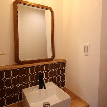 《 1F手洗い 》印象的なタイルが光る造作の手洗い場。 鏡は、実家のお母様から譲り受けられたもの。