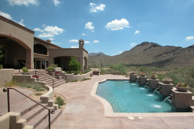Example of a large southwest backyard concrete paver and custom-shaped pool fountain design in Phoenix