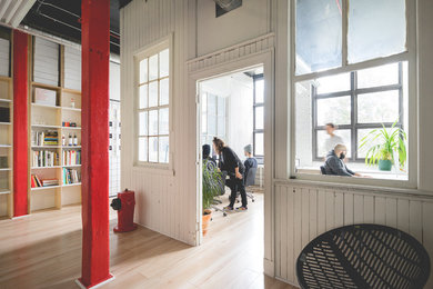 Example of a trendy built-in desk light wood floor home office design in Montreal with white walls