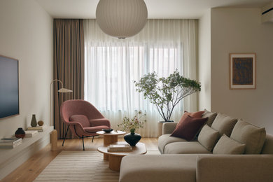 Example of a mid-sized trendy open concept medium tone wood floor and brown floor living room design in New York with a wall-mounted tv and gray walls
