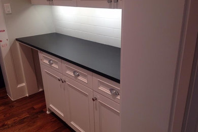 Example of a small classic single-wall medium tone wood floor home bar design in Dallas with recessed-panel cabinets, white cabinets, white backsplash and subway tile backsplash