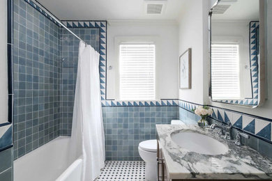Mid-sized eclectic kids' blue tile and porcelain tile porcelain tile, multicolored floor and single-sink bathroom photo in Dallas with recessed-panel cabinets, a two-piece toilet, white walls, an undermount sink, marble countertops, a niche and a freestanding vanity