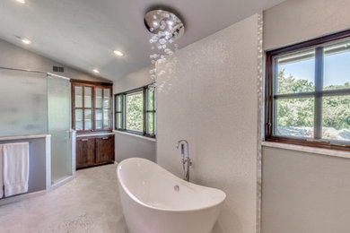This is an example of a mid-sized transitional master bathroom in Sacramento with a freestanding tub, a corner shower, white tile, grey walls, ceramic floors, grey floor, a hinged shower door and grey benchtops.